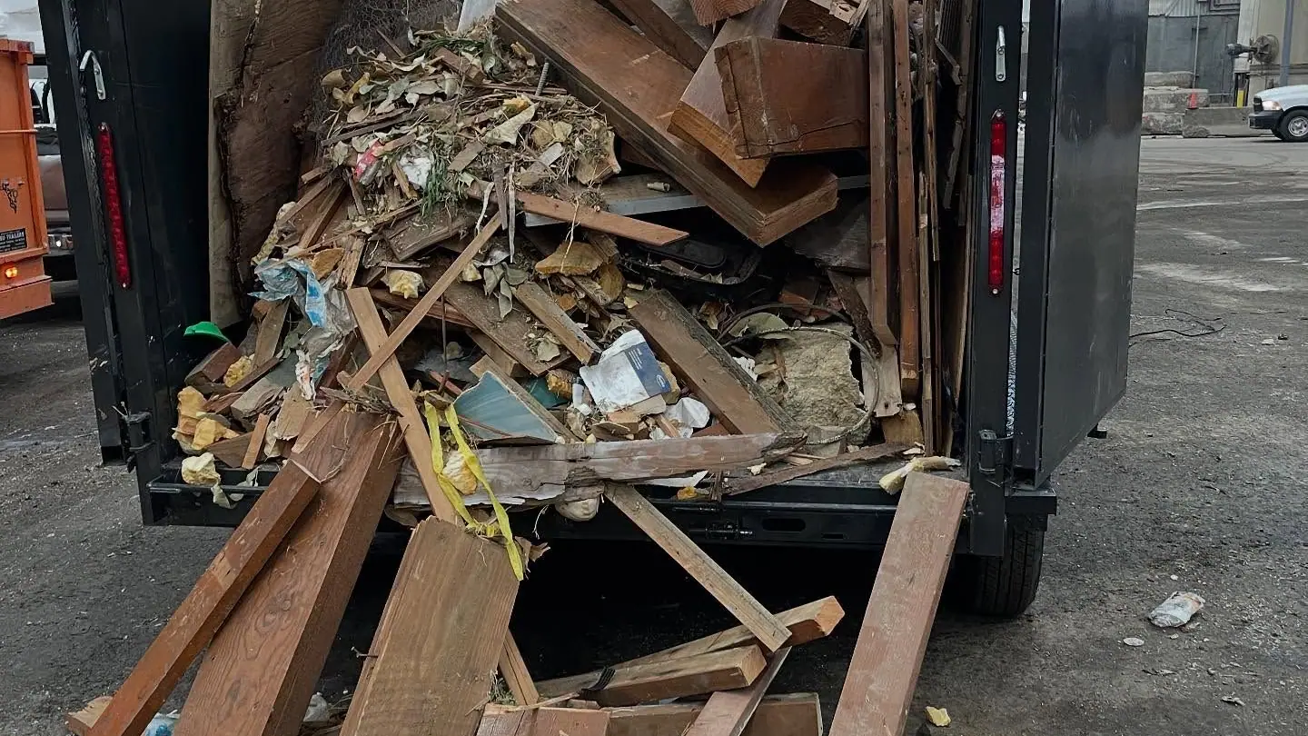 Cast Out dump trailer piled high with broken lumber and remodel debris