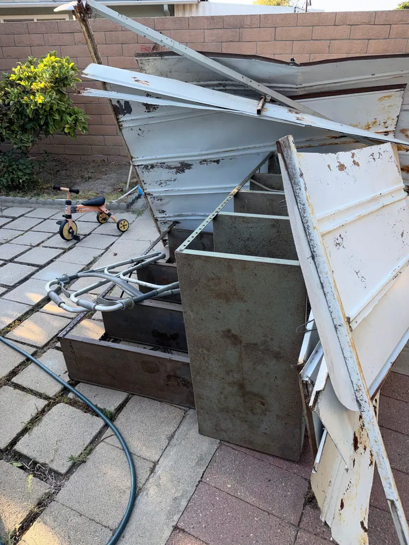 Old metal cabinets and scrap pulled out of a backyard for hauling