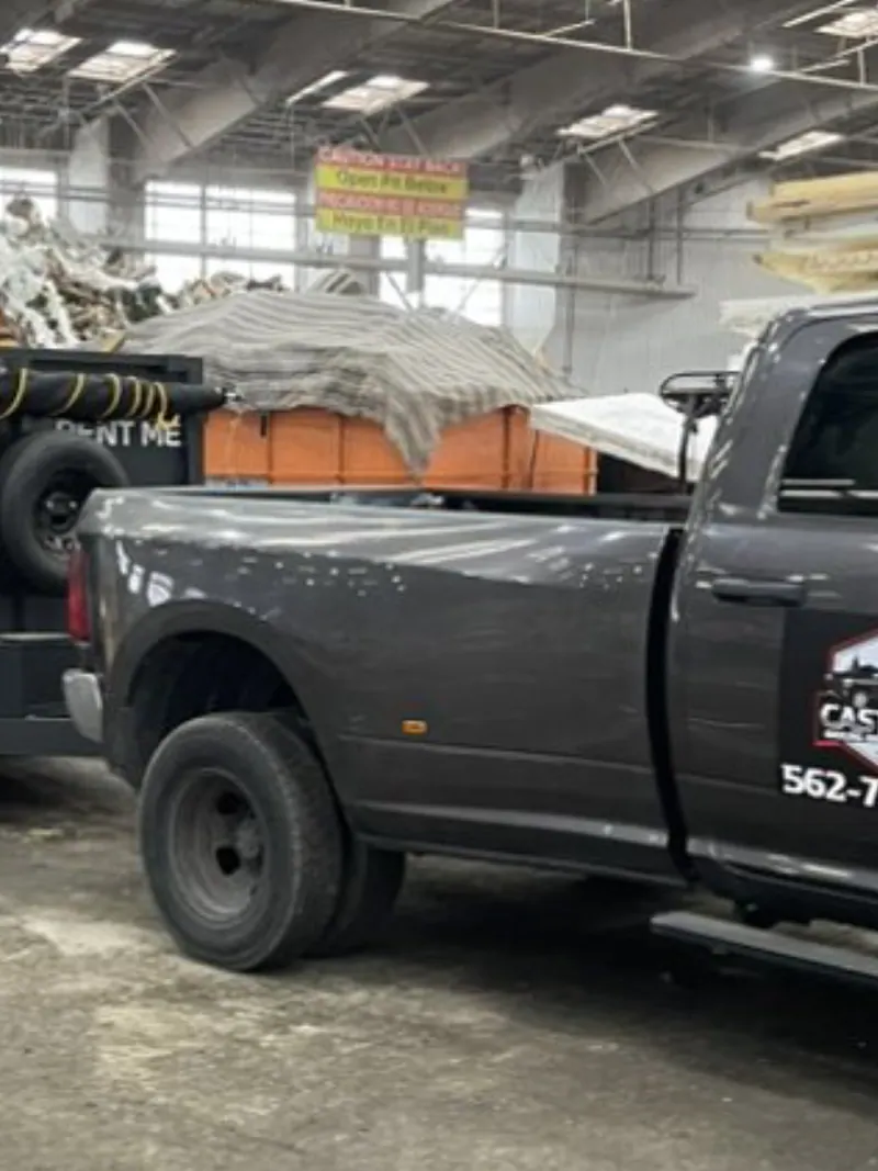 Cast Out pickup and loaded dump trailer parked in a transfer station unloading hall