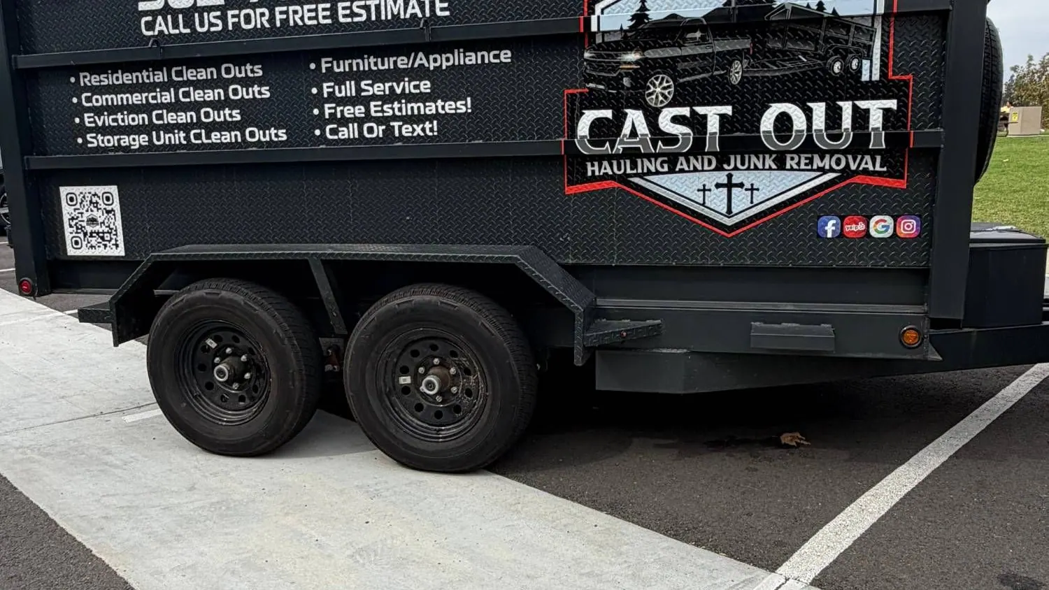 Side of the Cast Out hydraulic dump trailer with the logo, the phone number and the list of cleanouts