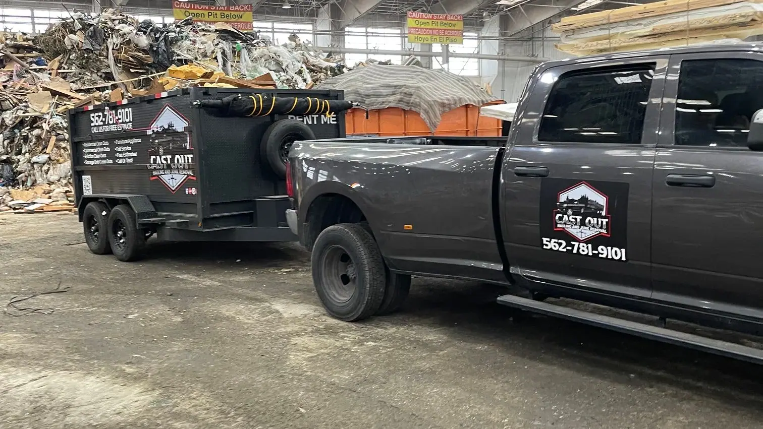 Cast Out pickup towing the dump trailer inside a large unloading hall