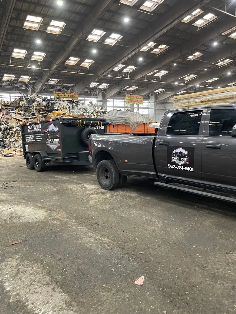 Cast Out pickup towing the dump trailer inside a large unloading hall